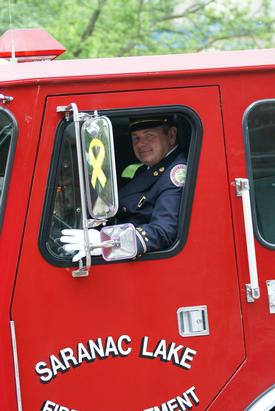 parade memorial dave fire engine saranac lake martelle rescue chief driving driver past leading through car