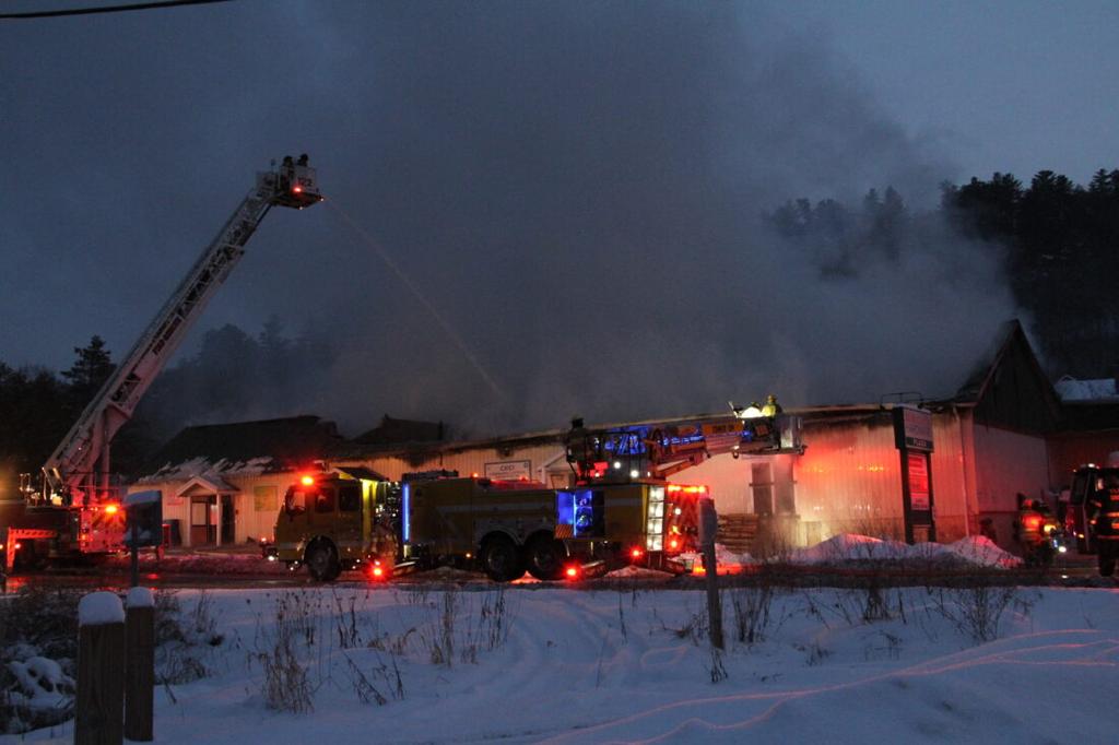 Firefighters from around the region were battling a blaze at the CED Twin Electric Supply building on upper Broadway, Saranac Lake, early Wednesday morning. The building is next to Aubuchon Hardware. (Enterprise photo — Andy Flynn)