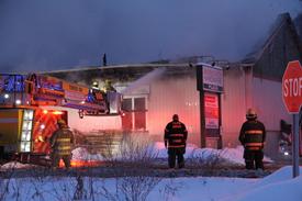 Firefighters from around the region were battling a blaze at the CED Twin Electric Supply building on upper Broadway, Saranac Lake, early Wednesday morning. The building is next to Aubuchon Hardware. (Enterprise photo — Andy Flynn)