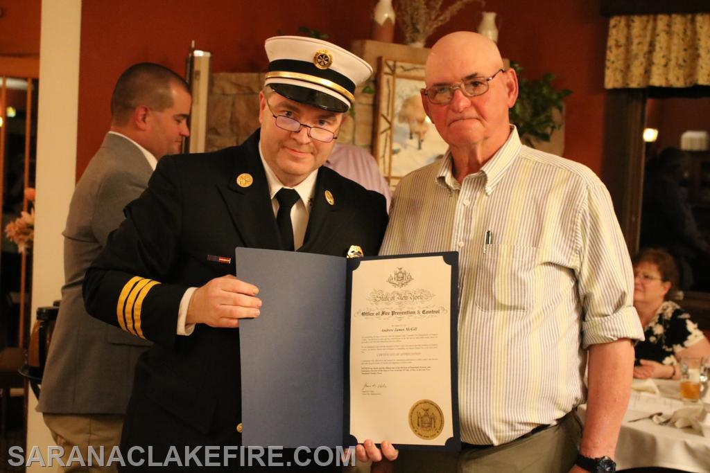 Ben Wheeler of the New York State Office of Fire Prevention and Control presents award to Andy McGill for 50 years of service with the SLVFD.