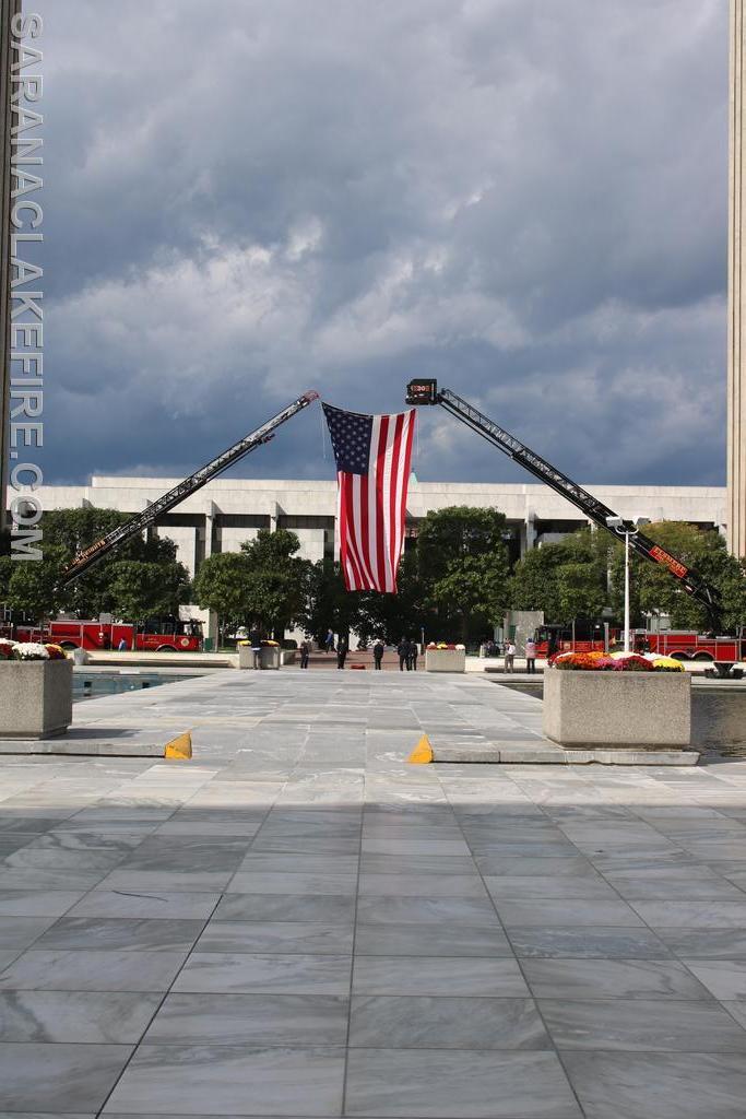 2 of 3 Ladder Trucks displaying US Flags around the Capital Plaza.