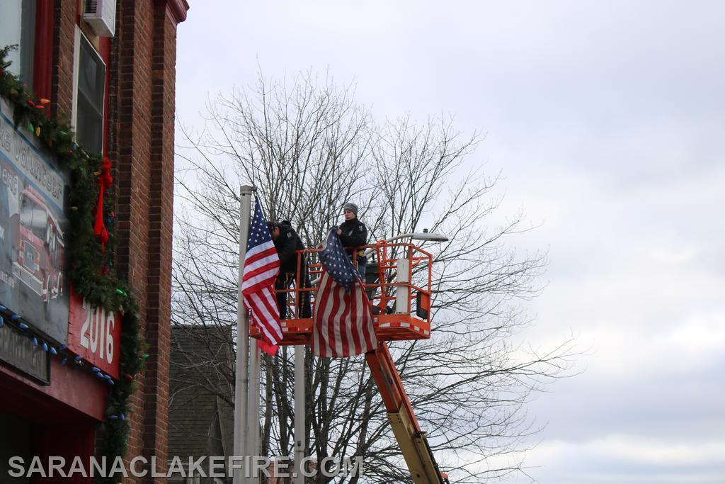 While the lift was at the firehouse SLVFD firefighters take the opportunity to replace the flags.