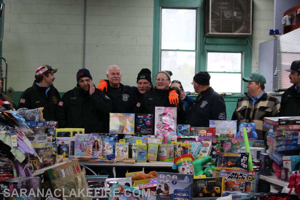 At the end of the event, SLVFD members and Holiday Helpers representatives take time to pose with the impressive pile of presents.