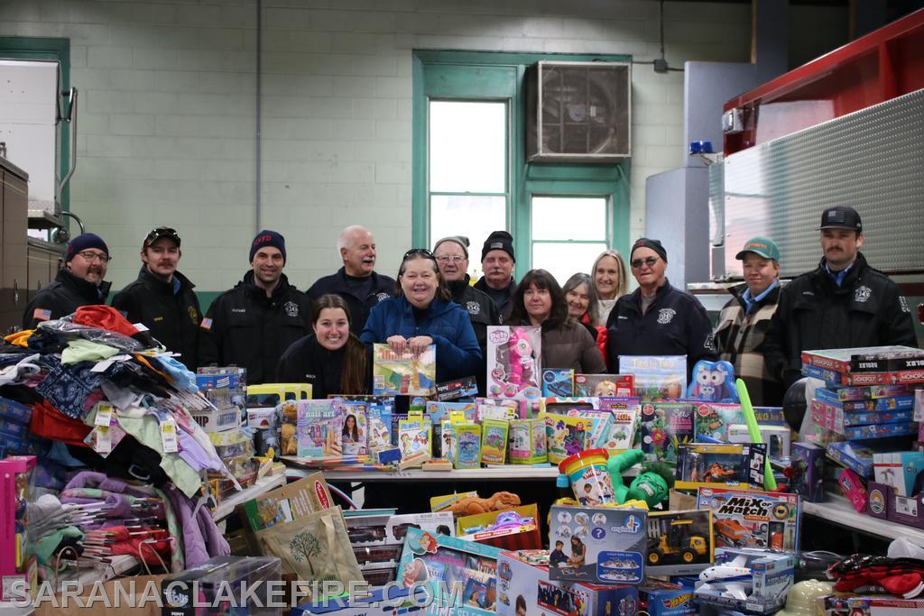 At the end of the event, SLVFD members and Holiday Helpers representatives take time to pose with the impressive pile of presents.